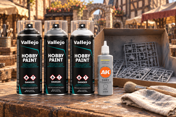 Vallejo Hobby Paint spray primers in black, grey and white and AK Interactive Grey Primer on a workbench in a Chapmen town yard